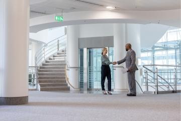 A photo of a school administrator shaking hands with an applicant